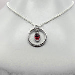 Oval cabochon rhodalite garnet pendant necklace in silver hammered ring